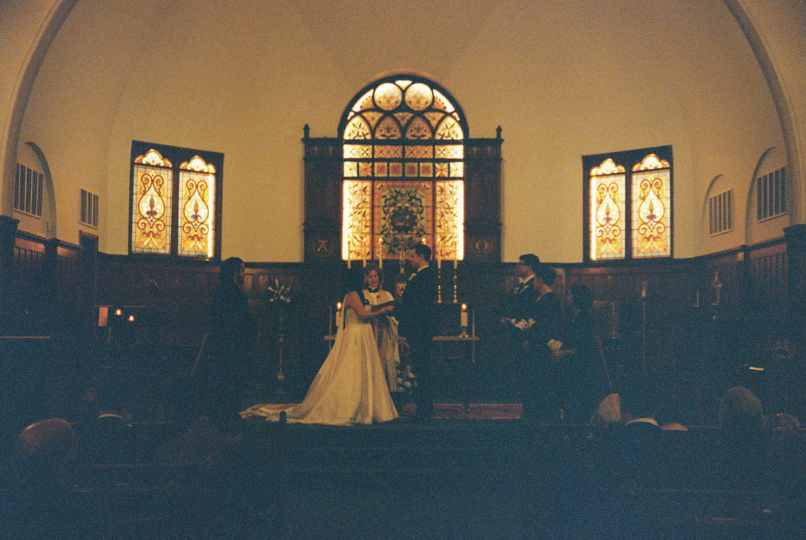 Wedding ceremony inside a candlelit stone chapel