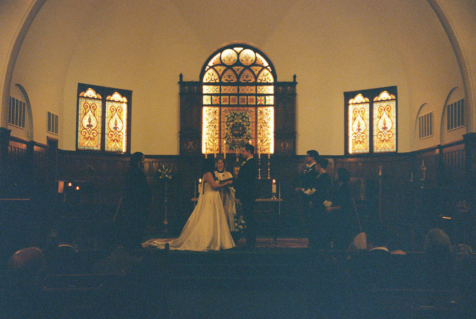 Wedding ceremony inside a candlelit stone chapel