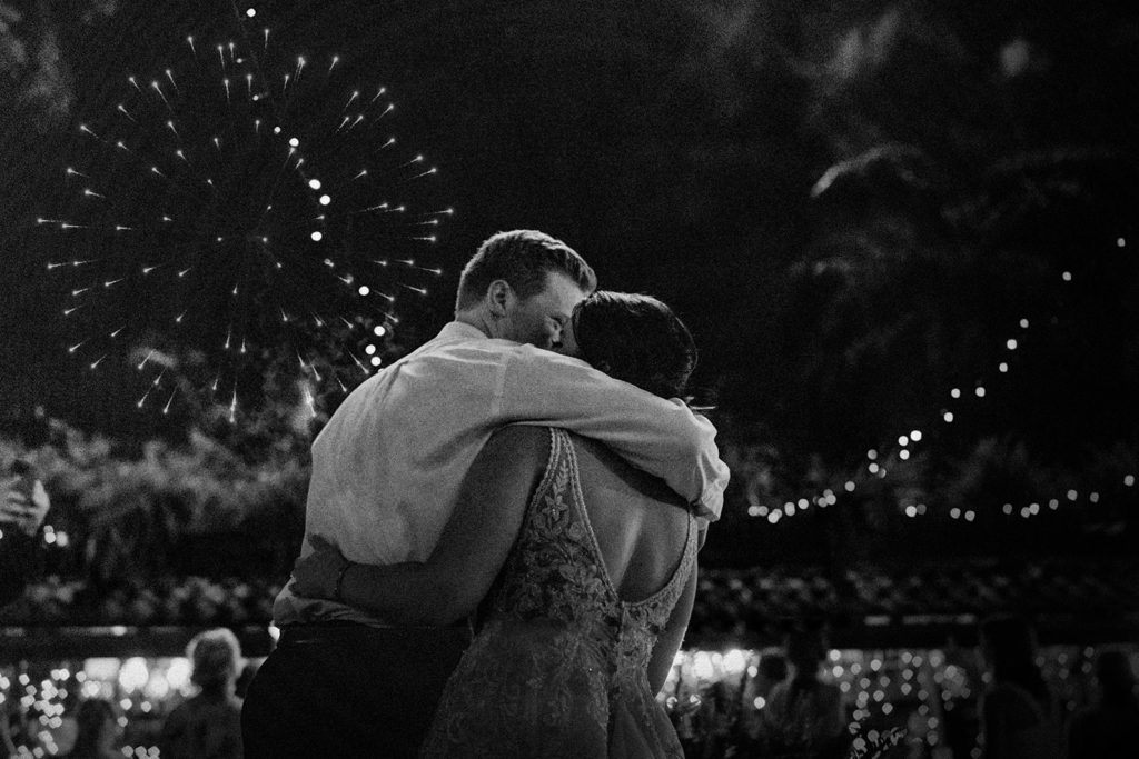 bride and groom kissing while fireworks go off at Hacienda Siesta Alegre