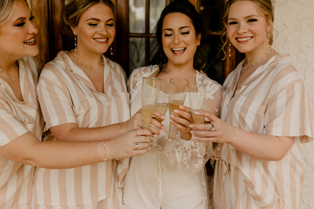 bride and bridesmaids cheers champaign at Hacienda Siesta Alegre venue