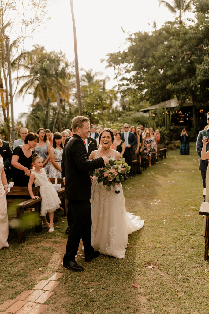 Bride and groom laughing while walking down the isle at the ceremony space in puerto rico