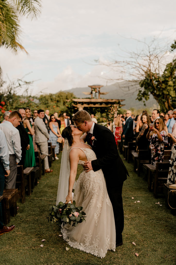 Bride and groom kissing for picture on the ceremony isle at Hacienda Siesta Alegre venue